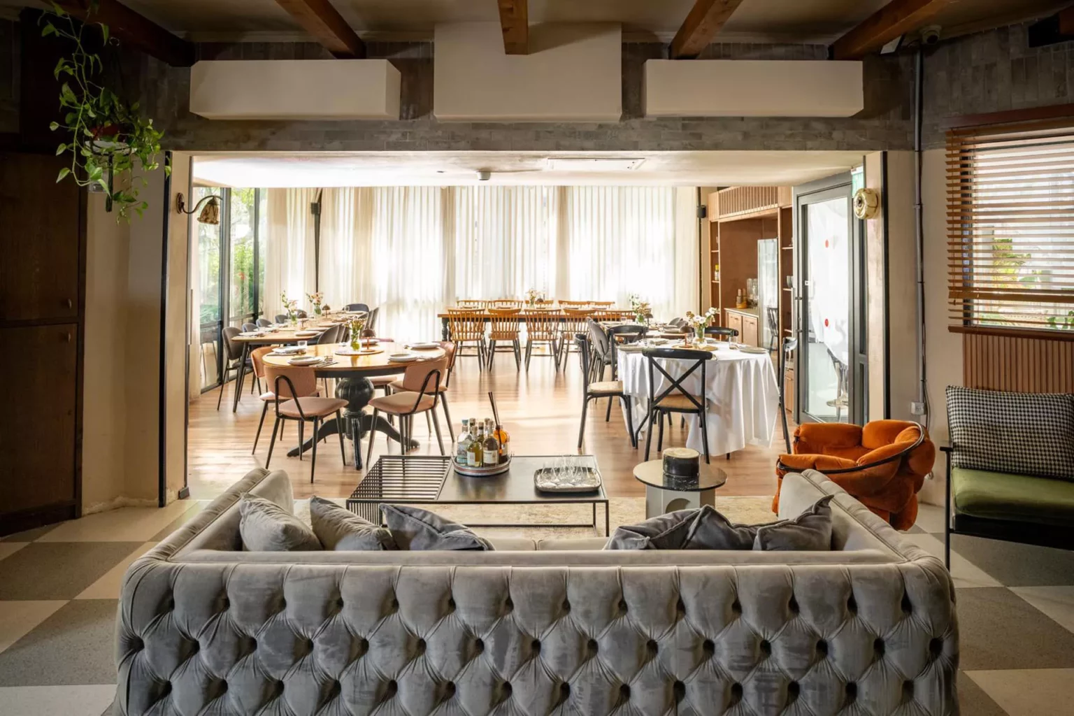 אירוח חלל אירוח פנימי מואר עם שולחנות ערוכים ואזור סלון פתוח