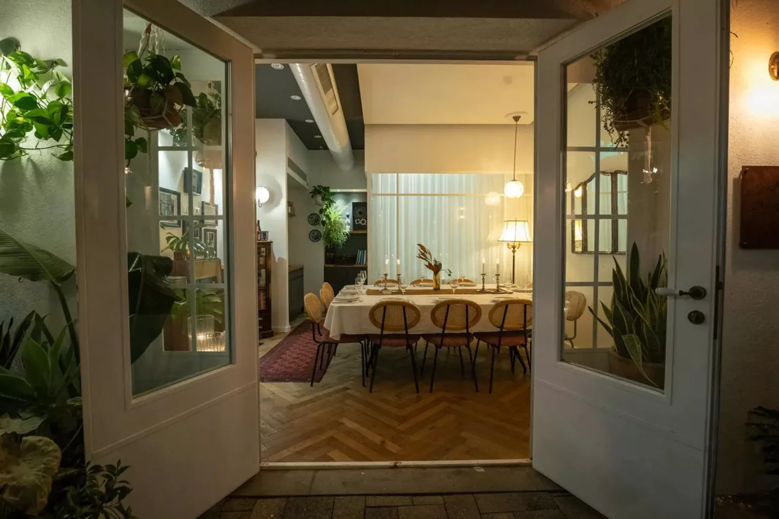 מבט דרך דלתות פתוחות אל חלל האירוח הערוך בבית השף